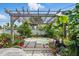 Backyard featuring an in-ground hot tub with a pergola and lush tropical landscaping for added privacy at 100 Lynnhurst Dr, Ormond Beach, FL 32176