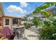 A serene backyard patio with a dining set, mature plants, and a charming pergola, perfect for outdoor relaxation at 100 Lynnhurst Dr, Ormond Beach, FL 32176