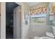 Bright bathroom featuring wainscoting, a decorative window, and an open door leading to another room at 100 Lynnhurst Dr, Ormond Beach, FL 32176