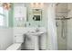 Bathroom featuring white wainscoting, a pedestal sink, a shower with chrome accents, and ample storage at 100 Lynnhurst Dr, Ormond Beach, FL 32176