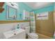 Bright bathroom with colorful walls, tan tile surround, and mermaid themed decor for a beachy feel at 100 Lynnhurst Dr, Ormond Beach, FL 32176