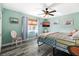 Bedroom featuring a ceiling fan, large window, wood-look flooring, and decoratively painted accent walls at 100 Lynnhurst Dr, Ormond Beach, FL 32176