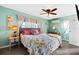 Bedroom with colorful decor, a ceiling fan, large window, and a bed with a bright quilt at 100 Lynnhurst Dr, Ormond Beach, FL 32176