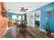 Dining room with a modern ceiling fan, hardwood floors, large windows, and bright blue walls at 100 Lynnhurst Dr, Ormond Beach, FL 32176