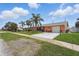 Charming home with a freshly sealed driveway and a lush, green lawn at 100 Lynnhurst Dr, Ormond Beach, FL 32176