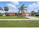 Lovely home featuring vibrant landscaping, a manicured lawn, and a stately palm tree at 100 Lynnhurst Dr, Ormond Beach, FL 32176