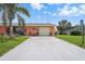 Well-maintained property with a freshly sealed driveway, lush lawn, and mature landscaping at 100 Lynnhurst Dr, Ormond Beach, FL 32176