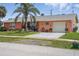 Exterior of home with attached garage, lush lawn, and mature landscaping at 100 Lynnhurst Dr, Ormond Beach, FL 32176