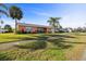 A single story pink home sits on a well manicured lawn, surrounded by palm trees at 100 Lynnhurst Dr, Ormond Beach, FL 32176