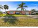 Charming single-story pink home with well-maintained lawn, landscaping, and a palm tree at 100 Lynnhurst Dr, Ormond Beach, FL 32176