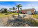 A single story pink home sits on a well manicured lawn, surrounded by palm trees at 100 Lynnhurst Dr, Ormond Beach, FL 32176