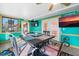 Cozy dining space in sunroom featuring bright teal walls, interesting decor and an adjacent door to the backyard at 100 Lynnhurst Dr, Ormond Beach, FL 32176