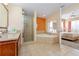 Primary bathroom featuring a double sink vanity, soaking tub, and glass enclosed shower at 12544 Floridays Resort Dr # 507-B, Orlando, FL 32821