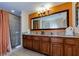 Modern bathroom featuring a double sink vanity, framed mirror, and walk-in shower at 12544 Floridays Resort Dr # 507-B, Orlando, FL 32821