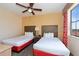 Bright bedroom features two twin beds, ceiling fan, and window view at 12544 Floridays Resort Dr # 507-B, Orlando, FL 32821