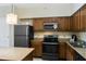 Modern kitchen with stainless steel appliances, granite countertops and wood cabinetry at 12544 Floridays Resort Dr # 507-B, Orlando, FL 32821