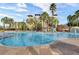 Exterior community pool surrounded by lounge chairs, palm trees, and a splash pad at 12544 Floridays Resort Dr # 507-B, Orlando, FL 32821