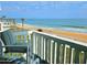 Relaxing balcony space with striped chairs and stunning views of the ocean and beach at 1575 Ocean Shore Blvd # 205, Ormond Beach, FL 32176