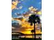 Beautiful sunset view of the bridge across the water with palm trees and clouds at 1575 Ocean Shore Blvd # 205, Ormond Beach, FL 32176