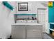 Functional laundry room with washer, dryer, and shelving for storage at 1705 Cordova Ave, Daytona Beach, FL 32117