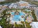 Aerial view of community pool with tiki huts, lounge chairs, and lush landscaping near residences at 243 Island Breeze Ave, Daytona Beach, FL 32124