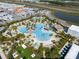 Aerial view of resort-style pool with tiki huts, beach entry, and playground in planned community at 243 Island Breeze Ave, Daytona Beach, FL 32124