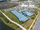 Aerial view of the community recreational area and commercial shopping center with tennis and pickleball courts at 243 Island Breeze Ave, Daytona Beach, FL 32124