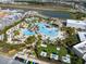 Aerial view of lagoon-style pool with tiki huts, lounge chairs, and community amenities in a modern community at 243 Island Breeze Ave, Daytona Beach, FL 32124