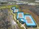 Aerial view of community tennis courts nestled between a nature preserve and residential neighborhood at 243 Island Breeze Ave, Daytona Beach, FL 32124