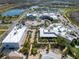 An aerial shot of a shopping center and recreational area including a pool, tennis courts and green spaces at 243 Island Breeze Ave, Daytona Beach, FL 32124