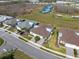 An aerial view of single-Gathering homes with tennis courts and green space in the background at 243 Island Breeze Ave, Daytona Beach, FL 32124