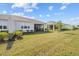 Lush backyard with green grass showcasing a glimpse of the screened-in patio at 243 Island Breeze Ave, Daytona Beach, FL 32124