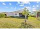 Well-manicured backyard showcasing the home's exterior, lanai, and surrounding landscape at 243 Island Breeze Ave, Daytona Beach, FL 32124