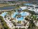 Aerial view of the community pool area with lush landscaping, tiki bars and comfortable lounge chairs at 243 Island Breeze Ave, Daytona Beach, FL 32124