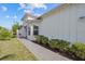 Exterior of home with manicured shrubbery, green grass, and partial brick walkway at 243 Island Breeze Ave, Daytona Beach, FL 32124