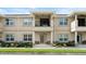 Townhome exterior featuring stone accents, covered entryways, and lush front yard landscaping at 3411 Gallia St, New Smyrna Beach, FL 32168