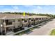 The exterior of this townhouse features dual balconies, a neutral color palette, and manicured landscaping at 3411 Gallia St, New Smyrna Beach, FL 32168