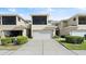 Rear view of townhome showcasing a two-car garage, screened patio, and well-maintained landscaping at 3411 Gallia St, New Smyrna Beach, FL 32168