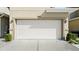 Attached garage with a white door, exterior lights, and concrete driveway at 3411 Gallia St, New Smyrna Beach, FL 32168