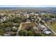 Expansive aerial view of a neighborhood, featuring a mix of residential and commercial buildings amidst lush trees at 630 W Rich Ave, Deland, FL 32720