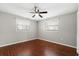 A comfortable bedroom is accentuated by wood floors, ceiling fan and two windows at 630 W Rich Ave, Deland, FL 32720