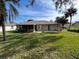 A spacious backyard with a screened lanai and lush green grass and a view of the home at 66 Old Sunbeam Dr, South Daytona, FL 32119