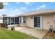 Backyard view of the house featuring a screened patio, bay window and mature trees and shrubs at 66 Old Sunbeam Dr, South Daytona, FL 32119