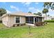 Backyard view of the house featuring a screened patio, mature trees and shrubs and manicured lawn at 66 Old Sunbeam Dr, South Daytona, FL 32119