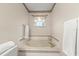 Elegant bathtub with tile surround and window at 66 Old Sunbeam Dr, South Daytona, FL 32119