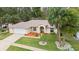 Charming home with well-manicured lawn, complemented by lush landscaping and mature palm trees at 66 Old Sunbeam Dr, South Daytona, FL 32119