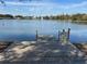 View of a serene lake featuring a dock, fountain, and wildlife for tranquil relaxation at 66 Old Sunbeam Dr, South Daytona, FL 32119