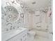 Bathroom with a decorative mirror, patterned wallpaper, and tiled shower at 8885 Sw 95Th St # C, Ocala, FL 34481