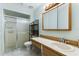 Well-lit bathroom with vanity, medicine cabinet, and tiled shower with sliding glass door at 1054 W Samms Ave, Port Orange, FL 32129