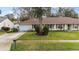 Charming single-story home featuring a well-manicured lawn, red shutters and an attached garage at 1054 W Samms Ave, Port Orange, FL 32129